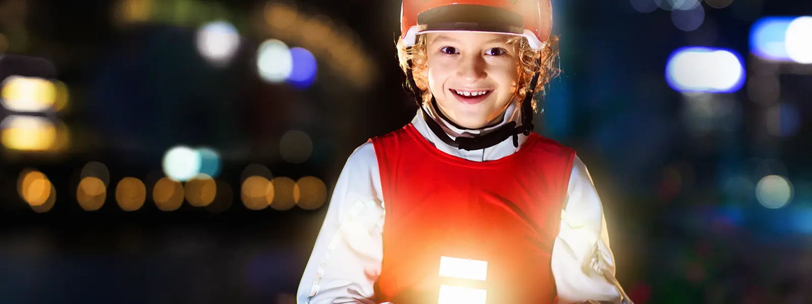 Barn i mörker på cykel som bär reflexer
